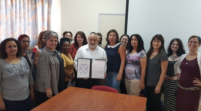 בן סימון וצוות האגף מציגים את תעודת ההוקרה